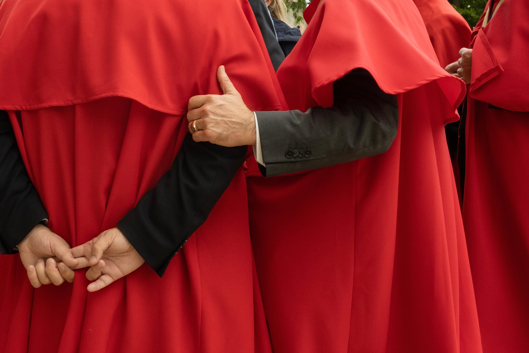Red robes and clasped hands