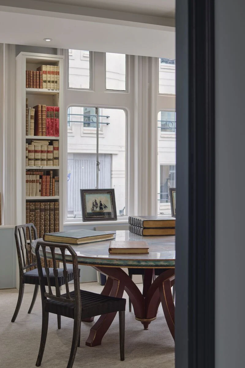 Reading room at Shapero with table, books and tall windows